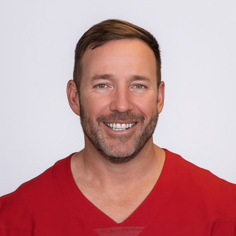 Smiling middle-aged Matt Prater wearing a red sports jersey against a white background