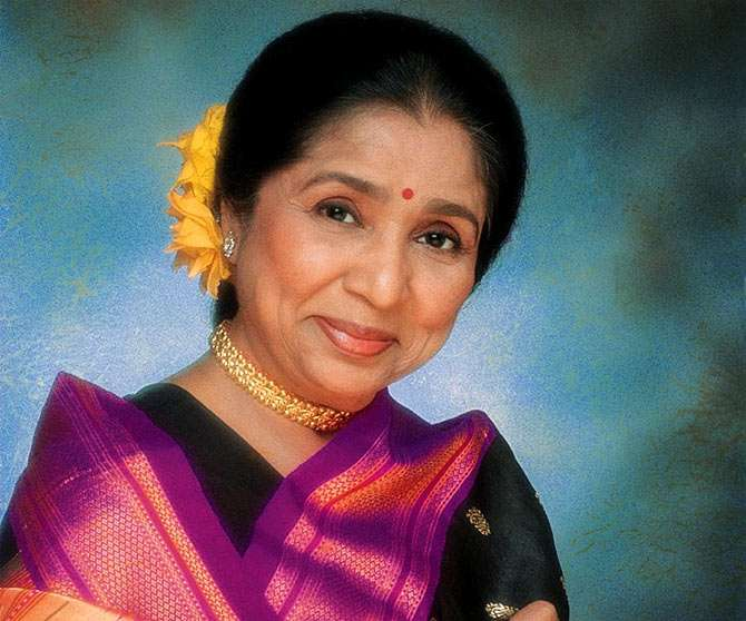 Asha Bhosle performing on stage, legendary Indian playback singer known for iconic Bollywood songs and a career spanning over seventy years.